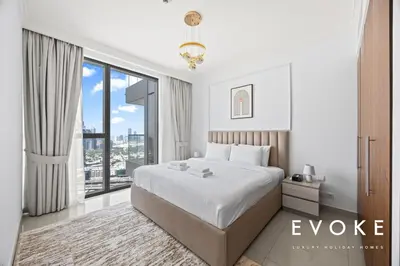 a bedroom with a large bed and a large window at Luxury 2BR by Evoke Burj & fountain View w Sofa bed & Balcony in Dubai