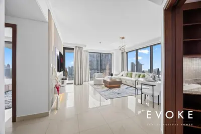 a living room with a couch and a table at Luxury 2BR by Evoke Burj & fountain View w Sofa bed & Balcony in Dubai