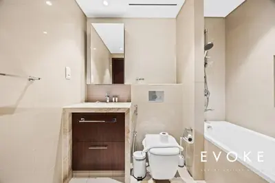 a bathroom with a toilet and a sink and a tub at Luxury 2BR by Evoke Burj & fountain View w Sofa bed & Balcony in Dubai