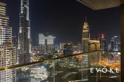 a view of a city skyline at night at Luxury 2BR by Evoke Burj & fountain View w Sofa bed & Balcony in Dubai