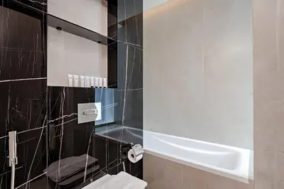 a bathroom with a tub and a toilet and a sink at Elegant 1BR Apartment Me Do Re Tower in JLT in Dubai