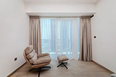 a living room with a chair and a window at Elegant 1BR Apartment Me Do Re Tower in JLT in Dubai