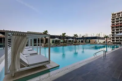 a large swimming pool with a bed and avisorvisorvisor at Inviting 1BR Apartment in JVC in Dubai