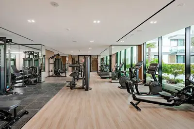 a gym with several treadmills and cardio machines at Inviting 1BR Apartment in JVC in Dubai