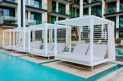 a group of white chairs next to a pool at Inviting 1BR Apartment in JVC in Dubai