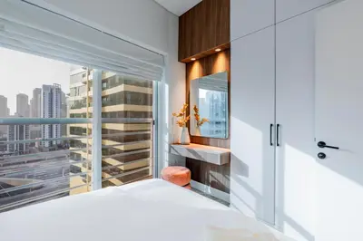 a bedroom with a white bed and a window at Luxury Lakeview Escape in Dubai
