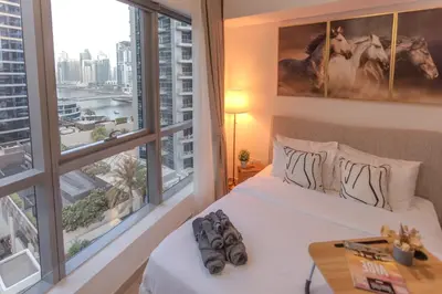 a bedroom with a bed and a large window at Stylish Studio Apartment with a Balcony Offering Sophistication, Spectacular Views & Beachside Living! in Dubai