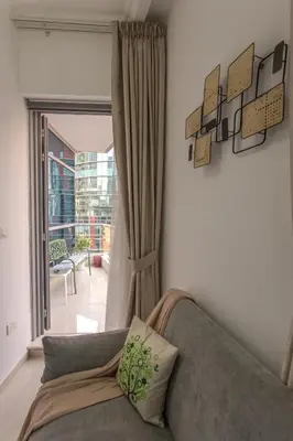 a living room with a couch and a large window at Stylish Studio Apartment with a Balcony Offering Sophistication, Spectacular Views & Beachside Living! in Dubai