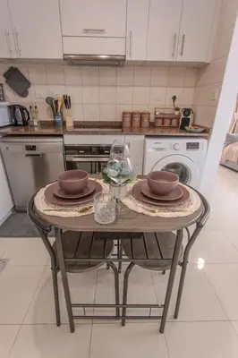 a kitchen with a table with plates and wine glasses at Stylish Studio Apartment with a Balcony Offering Sophistication, Spectacular Views & Beachside Living! in Dubai
