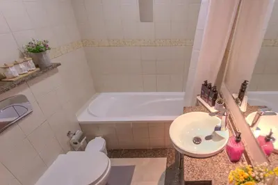 a bathroom with a tub and a sink and a toilet at Stylish Studio Apartment with a Balcony Offering Sophistication, Spectacular Views & Beachside Living! in Dubai
