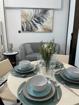 a table with plates and bowls on top of it at Cosy Studio in Opalz by Danube, Al Barsha South in Dubai