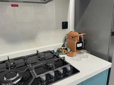 a kitchen with a stove and a counter with glasses at Cosy Studio in Opalz by Danube, Al Barsha South in Dubai