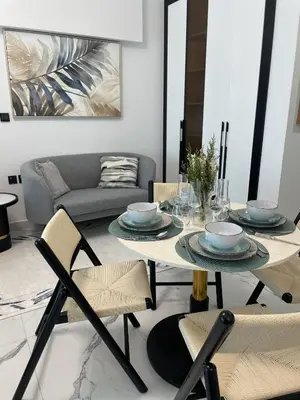 a dining table and chairs in a living room at Cosy Studio in Opalz by Danube, Al Barsha South in Dubai
