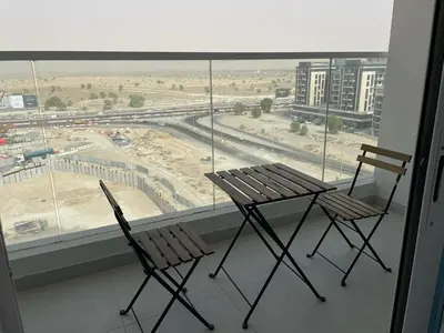 two chairs and a table in front of a window at Cosy Studio in Opalz by Danube, Al Barsha South in Dubai