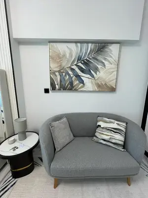 a living room with a couch and a painting on the wall at Cosy Studio in Opalz by Danube, Al Barsha South in Dubai