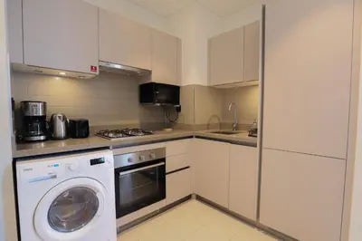 a kitchen with a washer and a washing machine at Cosy 1BR in Sobha Hartland in Dubai