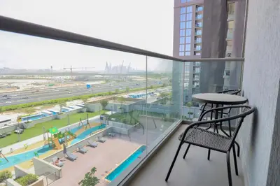 a balcony with a table and chair in a building at Cosy 1BR in Sobha Hartland in Dubai