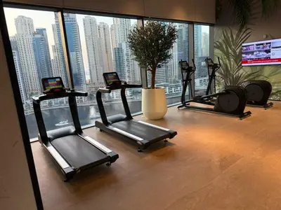 three exercise bikes in a room with a large window at Novity Signature Homes in Dubai