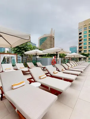 a row of lounge chairs and umbrellas on a rooftop at Novity Signature Homes in Dubai