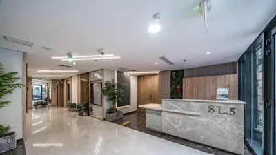 an office lobby with a reception desk and potted plants at A place like home in Dubai
