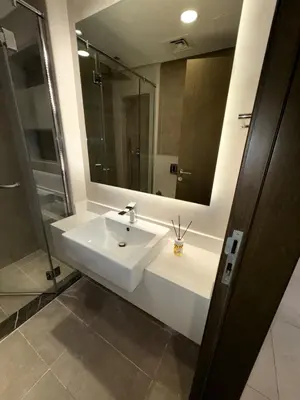 a bathroom with a white sink and a mirror at Stunning Studio Apartment in Jvc in Dubai
