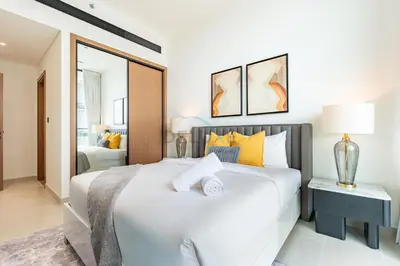 a bedroom with a large white bed and a mirror at Modern 2BR with Private Pool, Near Circle Mall And Quick Access from Al Khail Road, Binghatti Tulip, JVC by Deluxe Holiday Homes in Dubai