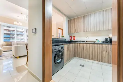 a kitchen with a washer and dryer in a room at Walking distance to Dubai Mall and Burj Khalifa, Easy access to Dubai Metro and Top attractions, Dunya Tower, Downtown Dubai by Deluxe Holiday Homes in Dubai