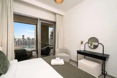 a bedroom with a white bed and a balcony at 4BR Gem in Downtown with Full Burj Khalifa View and Dubai Mall Access in Dubai