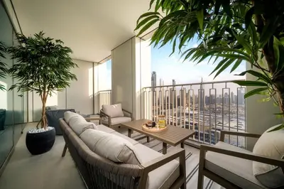 a living room with a couch and a balcony with plants at 4BR Gem in Downtown with Full Burj Khalifa View and Dubai Mall Access in Dubai