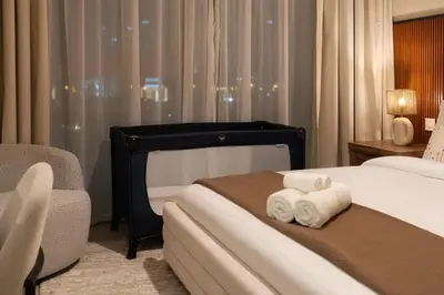 a hotel room with two beds and a chair at 2BR Gem with Burj Khalifa View and Dubai Mall Access in Dubai