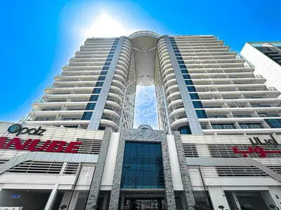 a tall white building with a sign on it at Royalton - Private Pool Luxe Studio in Dubai in Dubai