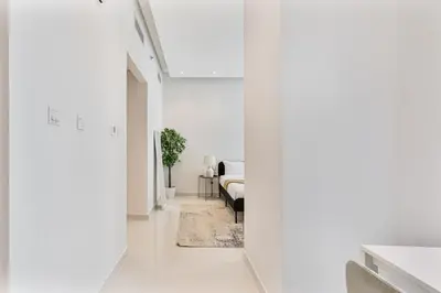 a hallway with white walls and a room with beds at Elegant Studio in Business Bay near Burj Khalifa in Dubai