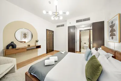 a bedroom with a large bed and a mirror at Stylish 1BR in Dubai Marina with Balcony, Pool & Walk to Beach in Dubai