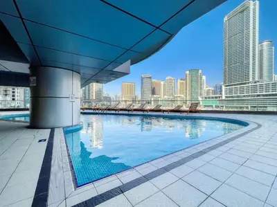 a swimming pool with a city skyline in the background at Stylish 1BR in Dubai Marina with Balcony, Pool & Walk to Beach in Dubai