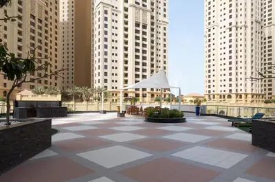 a courtyard in a city with tall buildings at Stylish 1BR in Dubai Marina with Balcony, Pool & Walk to Beach in Dubai