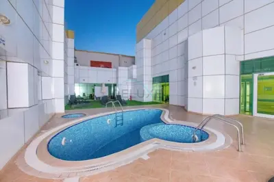 a building with a swimming pool in the middle of it at Chic Waterfront Location with Direct Metro Access and a Glimpse of Ain Dubai, Lake City Tower, Jumeirah Lake Towers by Deluxe Holiday Homes in Dubai