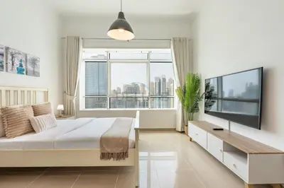a bedroom with a large bed and a large window at Chic Waterfront Location with Direct Metro Access and a Glimpse of Ain Dubai, Lake City Tower, Jumeirah Lake Towers by Deluxe Holiday Homes in Dubai