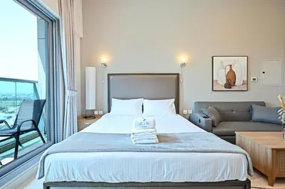 a bedroom with a large bed and a couch at Luxury Studio Near Downtown Dubai in Dubai
