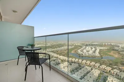 a room with a table and chairs on a balcony at BirdsEye Cozy Studio Mesmerizing Golf Views in Dubai