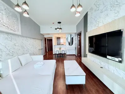 a living room with a white couch and a flat screen tv at Charming 1 BR with Balcony Retreat in Dubai