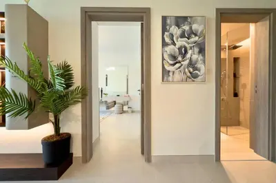 a hallway with a plant and a painting on the wall at Luxury 1-Bedroom Apartment with Full Marina View in Dubai