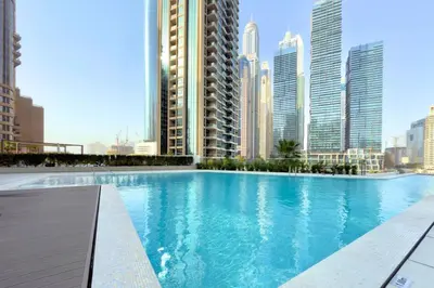 a large swimming pool in a city with tall buildings at Luxury 1-Bedroom Apartment with Full Marina View in Dubai
