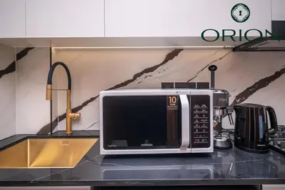 a microwave sitting on top of a kitchen counter at Stunning Luxury Studio with Jacuzzi and Canal View on High Floor, Close to Dubai Mall, Swimming Pool, Advanced Gym with PT, Sauna, Steam Room, Ice Bath, Swimming Pool, Best Building in Area in Dubai