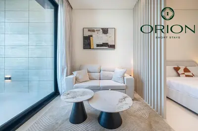 a living room with a couch and a table at Stunning Luxury Studio with Jacuzzi and Canal View on High Floor, Close to Dubai Mall, Swimming Pool, Advanced Gym with PT, Sauna, Steam Room, Ice Bath, Swimming Pool, Best Building in Area in Dubai
