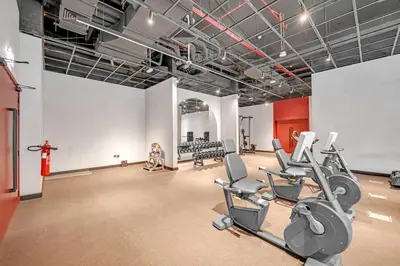 a gym with treadmills and cardio equipment in a room at Waves - Cozy & Modern JVC Escape With Pool & Gym Access in Dubai