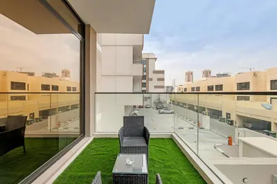 a balcony with two chairs and a view of a street at Waves - Cozy & Modern JVC Escape With Pool & Gym Access in Dubai