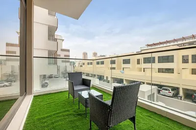 a balcony with chairs and a view of a building at Waves - Cozy & Modern JVC Escape With Pool & Gym Access in Dubai