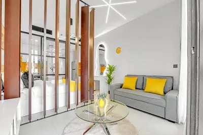 a living room with a couch and a table at Waves - Cozy & Modern JVC Escape With Pool & Gym Access in Dubai