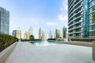 a swimming pool with a city skyline in the background at Panoramic High-Floor 1BR Overlooking Yachts and Dubai Water Canal, Moments from JBR Beach, LIV MarinaMarine Transport, and Skydive Dubai, LIV Marina, Dubai Marina by Deluxe Holiday Homes in Dubai