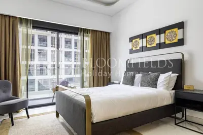 a bedroom with a bed and a large window at Bloomfeilds Comfortable STU Azizi Rivera in Dubai